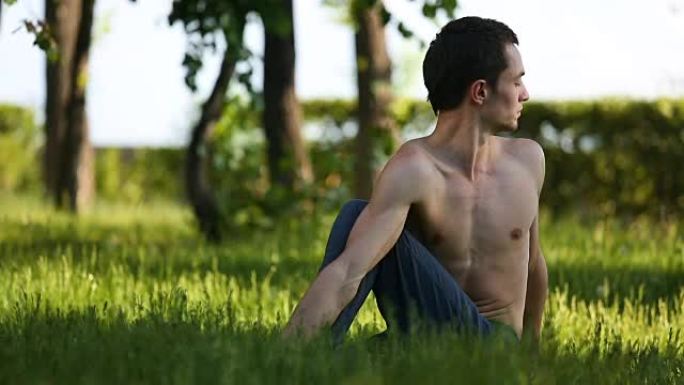 专业瑜伽男子在公园练习。裸胸的男人做瑜伽姿势