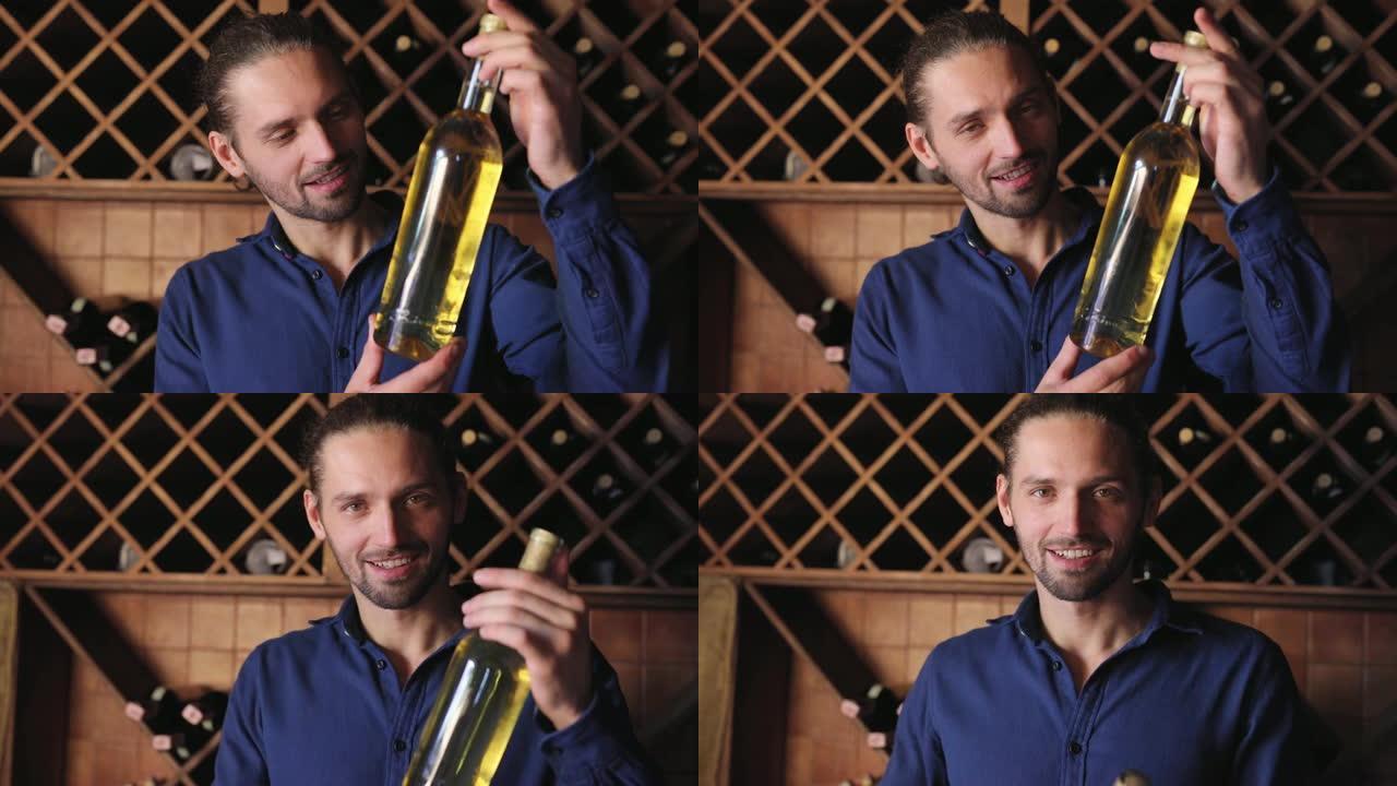 微笑的男人在酒庄餐厅的酒窖里喝一瓶葡萄酒