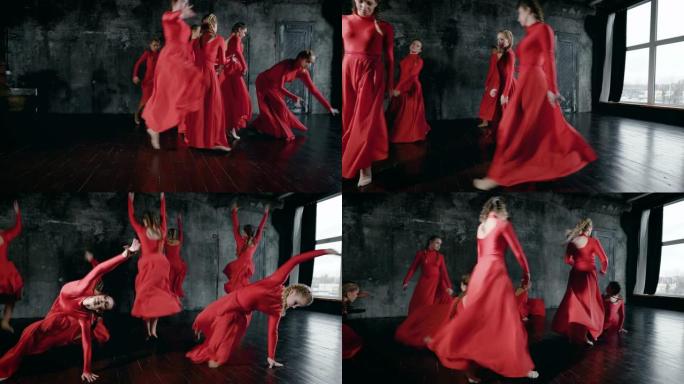 一群年轻的舞者女孩穿着红色长裙在黑暗的大厅里排练，表演