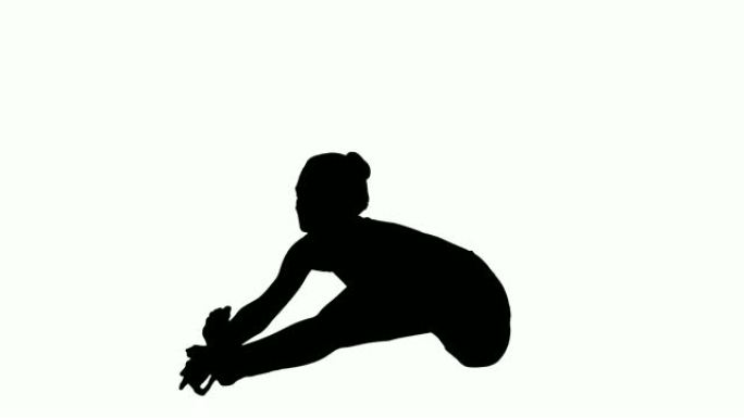 剪影年轻迷人的女人练习瑜伽，坐在头到膝盖前弯曲锻炼，Janu Sirsasana姿势