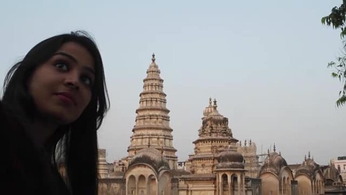 女人在全景吸引人的华丽的寺庙要塞宫殿建筑群前，从一个有利的角度，在更高的水平上用手机相机自拍，游客印