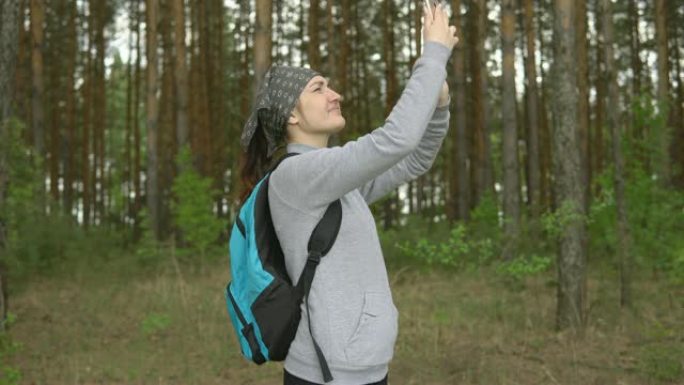 森林中的年轻女子试图捕捉移动信号