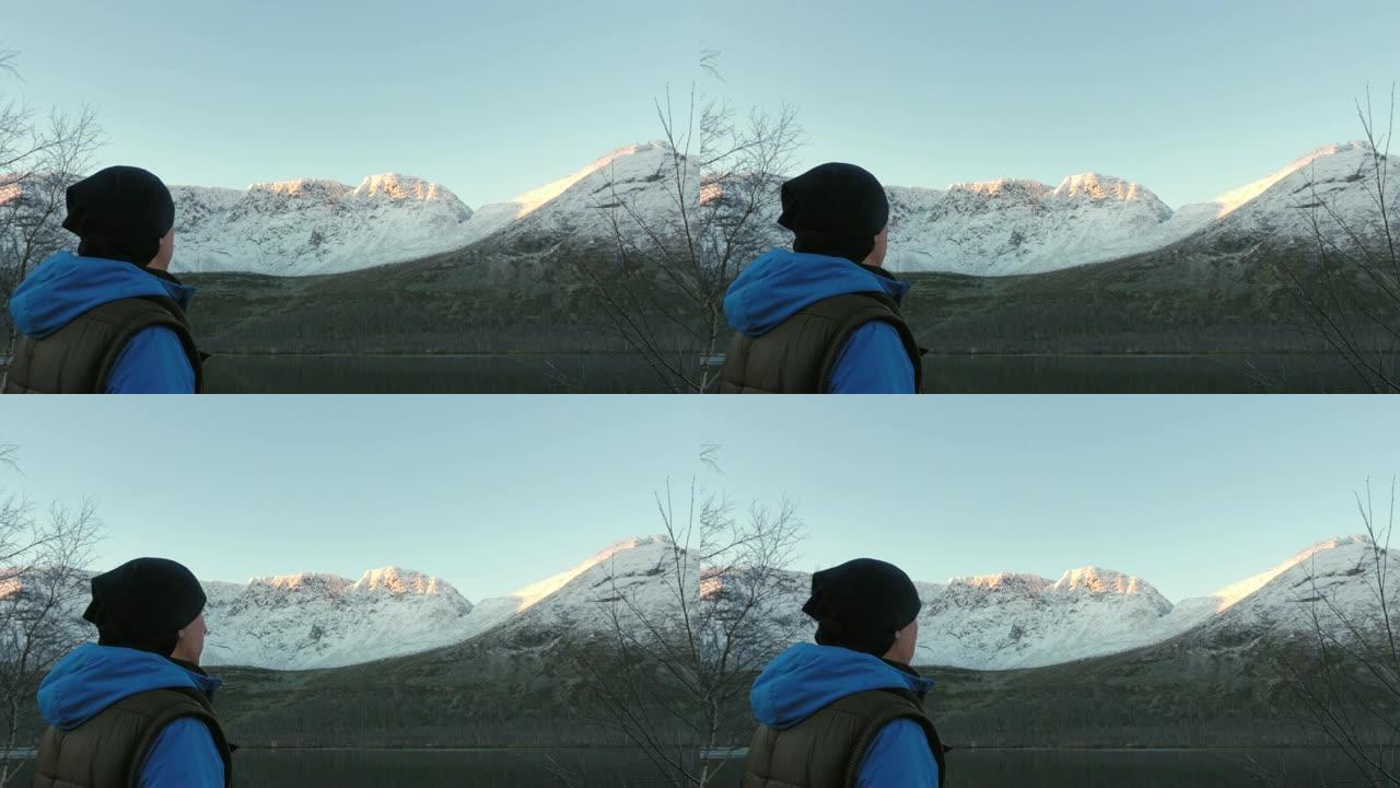 一个男人，一个中年运动员，在山里遇见黎明。他非常欣赏太阳和湖中山脉的反射。