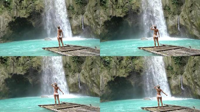年轻女子正在考虑菲律宾宿雾岛上美丽的瀑布。人们旅行热爱自然的概念。一个人只在和平的环境中享受户外和宁