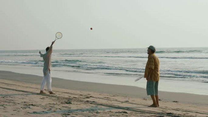 活跃的高级夫妇在海滩玩太极气球。