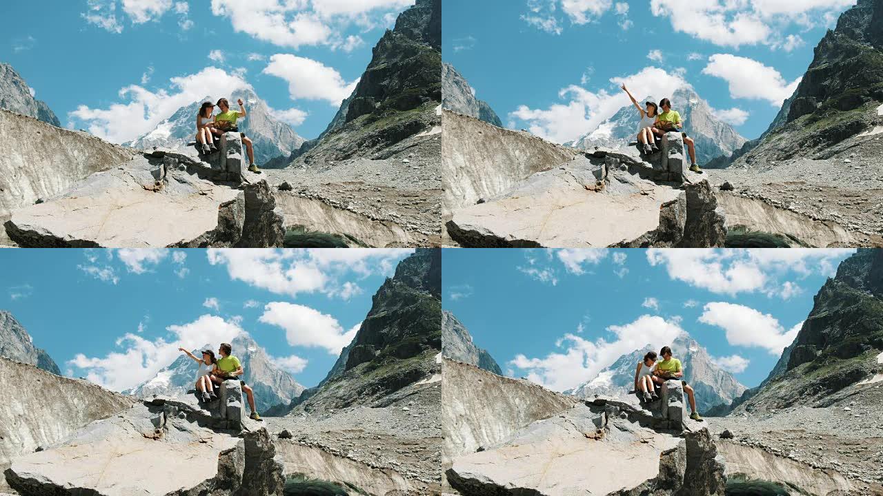 几个游客坐在岩石上，研究地图，计划登山路线。