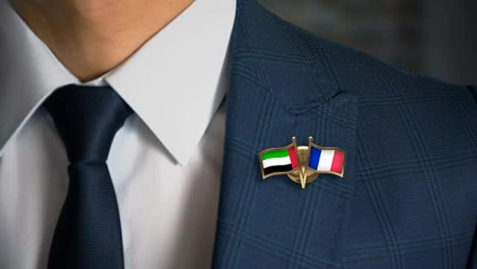 商人带着朋友国家的国旗走向相机，别针阿拉伯联合酋长国-法国