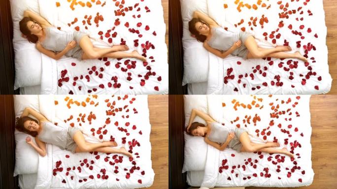 幸福的女人躺在玫瑰花瓣的床上。从上面的观点