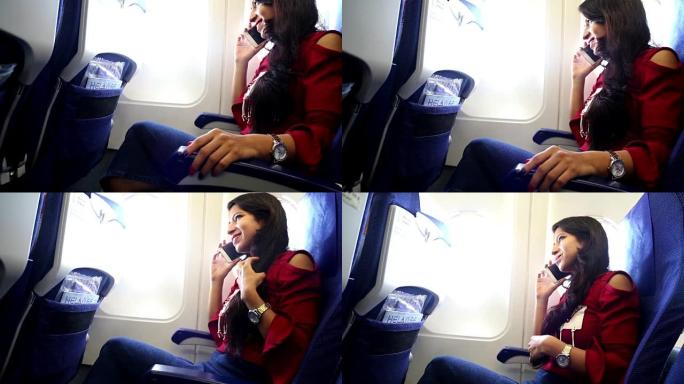 年轻女子坐在飞机上，用手机聊天