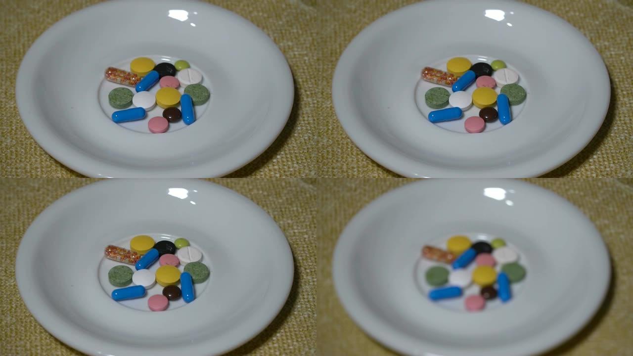 药丸。药物特写。一堆多色药片躺在一个白色的碟子上。生物活性添加剂和维生素。特写。慢动作。