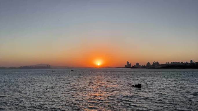 青岛海岸线日落，海边日落，远处建筑剪影