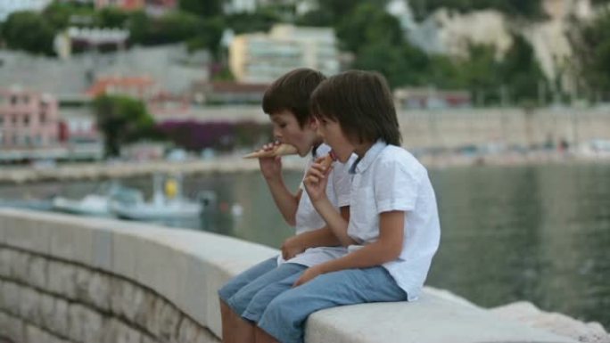 可爱的孩子，男孩，一边吃冰淇淋，一边欣赏法国里维埃拉Villefrance的海港景色