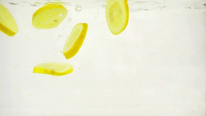 圆形柠檬片慢慢沉入水中，慢动作特写