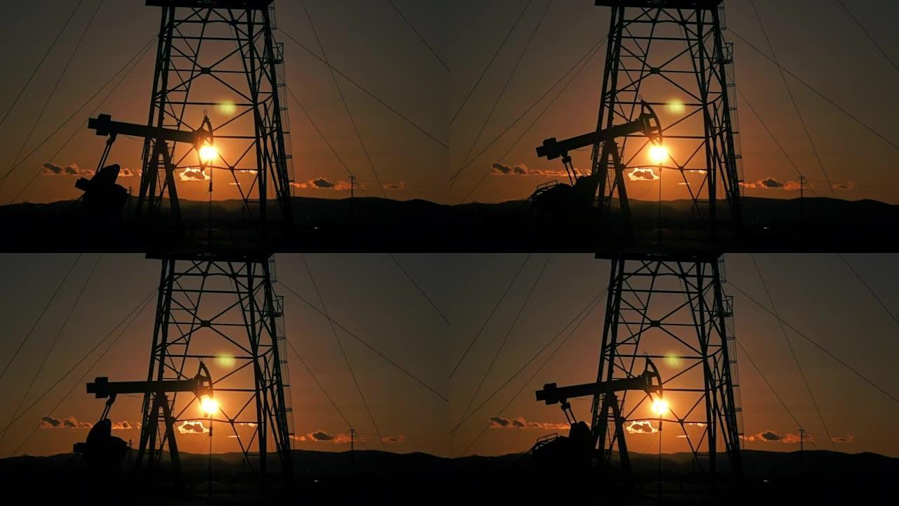 石油井架机构在夕阳下，石油生产。日落时的油泵