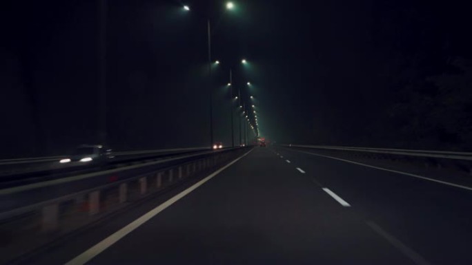 汽车在黑暗中沿着高速公路快速行驶。