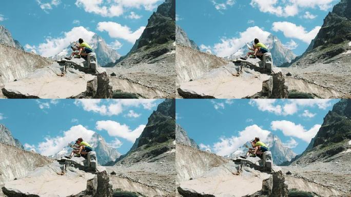 几个游客坐在一块岩石上，研究一张纸质地图，规划登山路线。