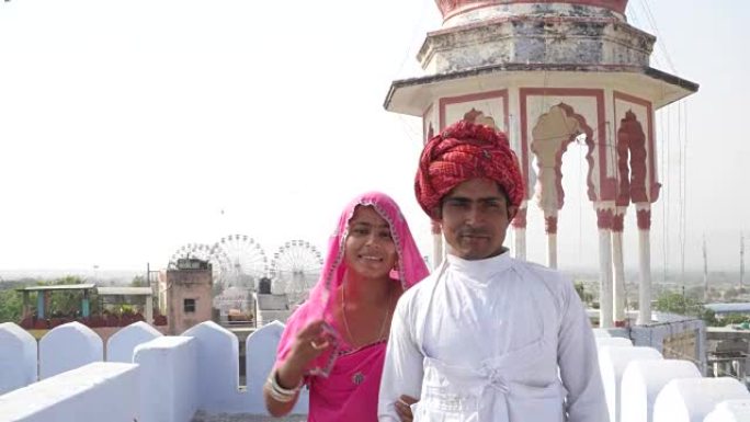 在印度拉贾斯坦邦的一个屋顶上，英俊的男人和美丽的女人自信地走在一起