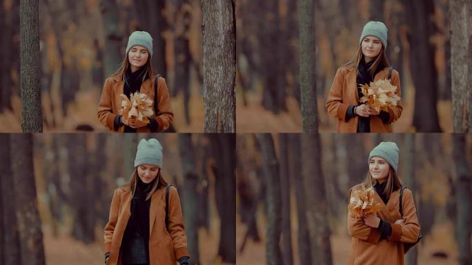 秋天森林中一个女孩的肖像，一束橙色的叶子