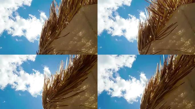 蓝天下的草编沙滩伞，随风运动，暑假预订