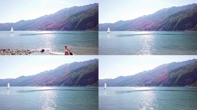 无人驾驶飞机在湖岸拍摄的年轻女子，红色独木舟在地图上寻找方向，准备在夏天在瑞士的山湖探索大自然