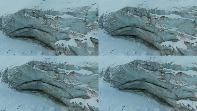 鸟瞰图特写边缘流动的冰川覆盖着高山上的雪和石头。冰川融化的自然破坏和全球变暖