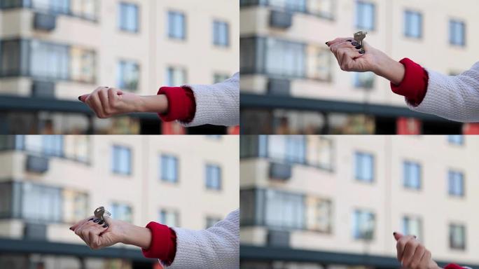 双手给公寓钥匙的特写镜头。女人将钥匙传给新所有者