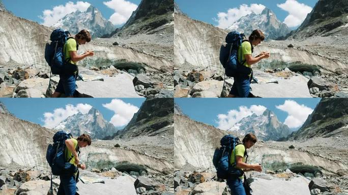 游客男子背着背包在地图上探索路线，并拨打GPS电话，添加地图并在山间远足中走路线