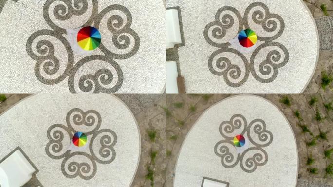 希腊圣托里尼岛女子旋转彩虹伞的鸟瞰图。