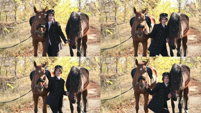 豪华的年轻女孩在温暖的秋天天气里和两匹马在森林里散步。
