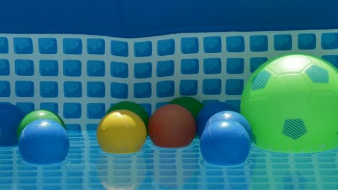 不同颜色的球漂浮在一个小型夏季游泳池的水中