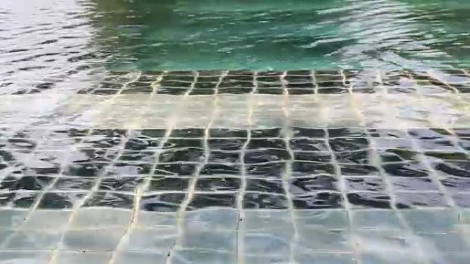 蓝色游泳池与波浪移动反射闪亮的背景在夏天，撕裂的水，自然放松的概念。