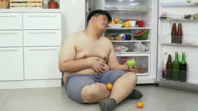 多莉 (dolly) 前视图: 超重的泰国男子一直在吃冰箱，直到他在冰箱里睡觉。