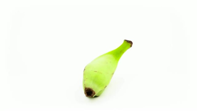 一整根绿色烹饪穆萨香蕉。在转盘上旋转。孤立在白色背景上。特写。宏观。