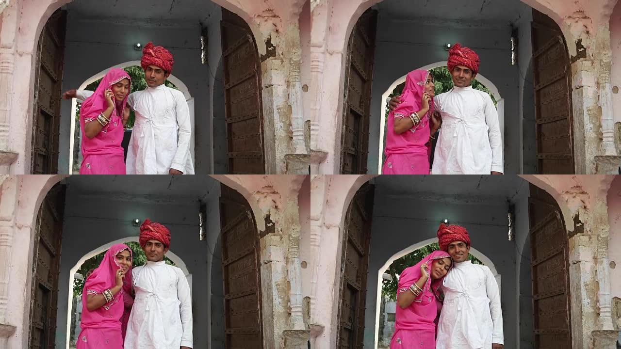 印度夫妇站在他们在印度拉贾斯坦邦的传统老房子里为相机摆姿势