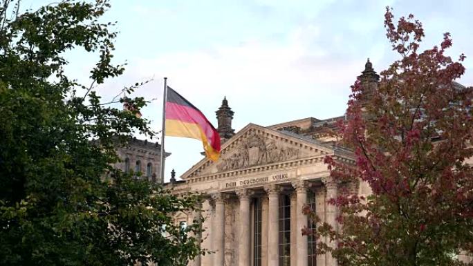 德国柏林的国会大厦和德国国旗被树木框住
