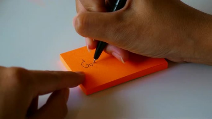 在橙色的便签纸或记事本纸上手写 “好运” 一词。运动4k镜头