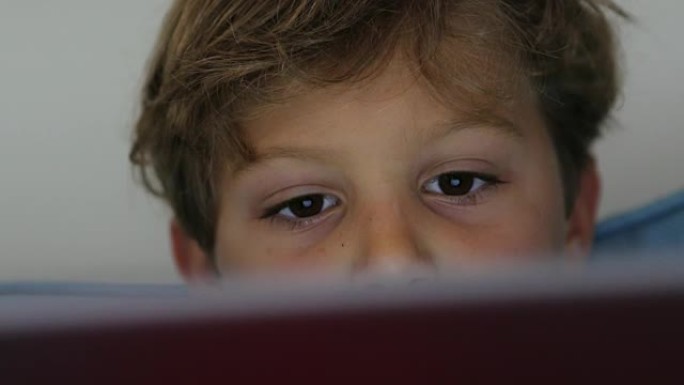 儿童使用平板电脑技术设备。小男孩在4K屏幕上主演