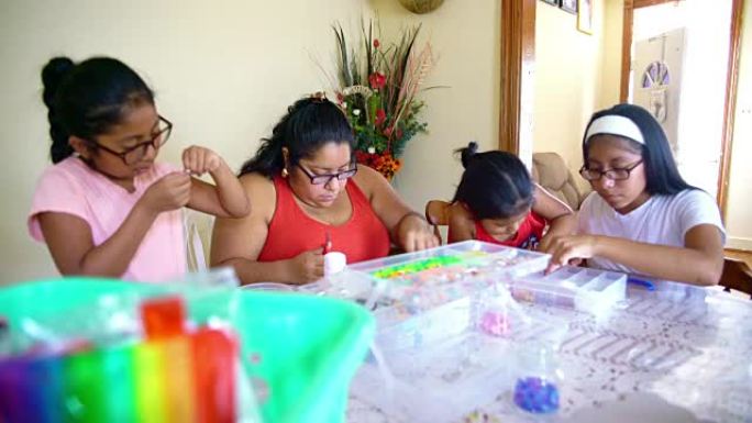 快乐的墨西哥裔美国家庭一起做手工，做精美的珠饰。