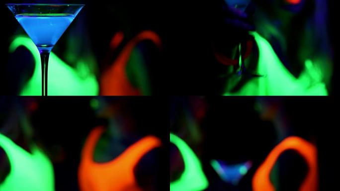 蓝色发光饮料与跳舞的女人在紫外线发光派对背景和女人来拿饮料。。
