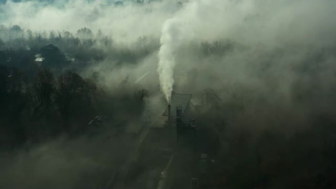 从工厂烟囱中冒出的工业烟雾的鸟瞰图被雾堤覆盖。