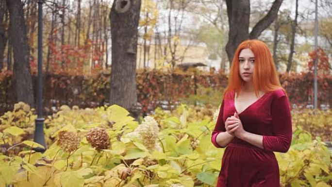 沉思的年轻女孩走过秋天的公园