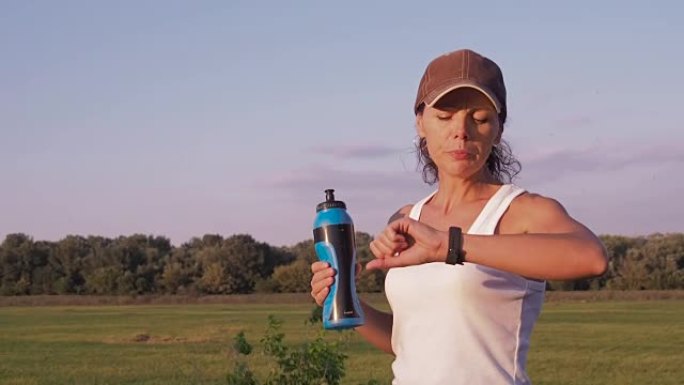 一个运动女人正在喝水。
