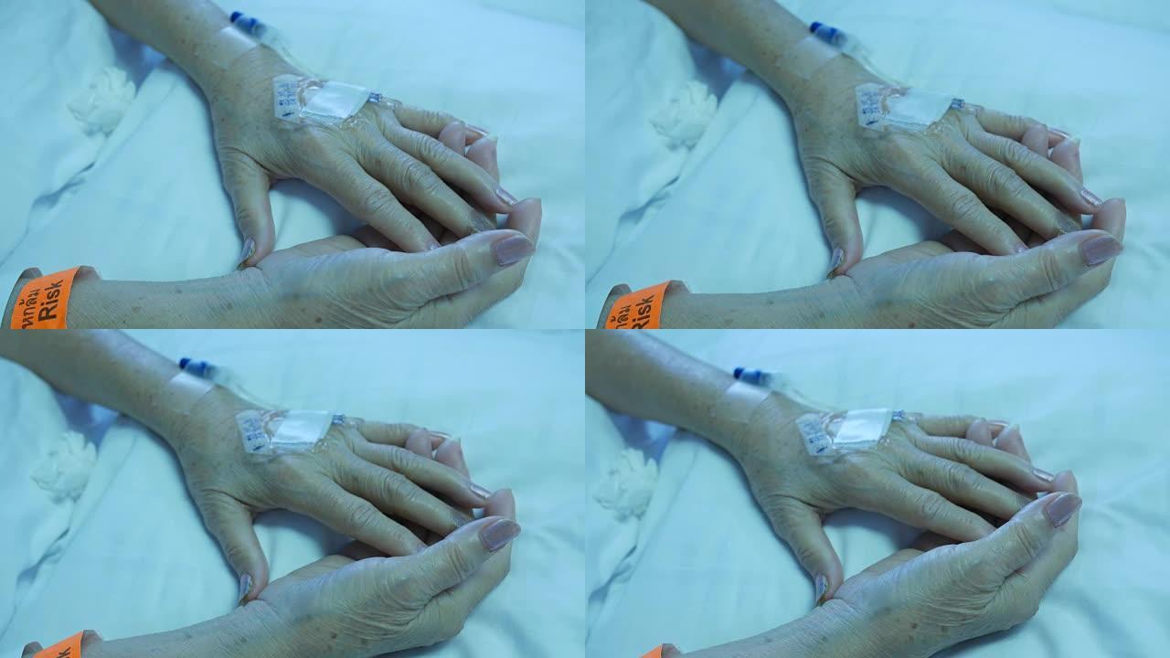 老年患者的手躺在床上，生理盐水