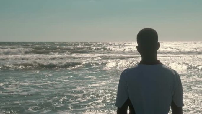 迁徙，大海，象征。年轻的黑人观察海景