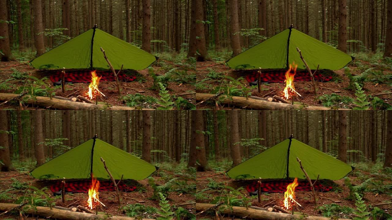 丛林风格防水布设置前熊熊篝火。森林荒野深处一个营地的镜头。