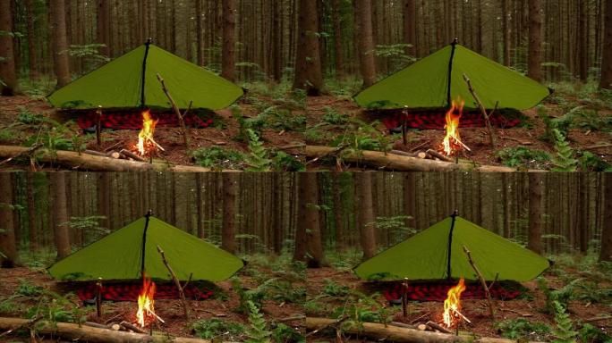 丛林风格防水布设置前熊熊篝火。森林荒野深处一个营地的镜头。