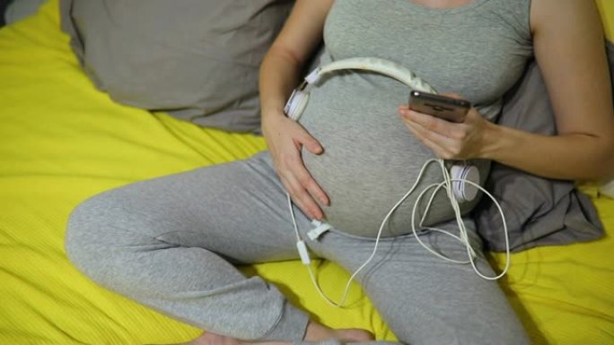 孕妇肚子上拿着耳机