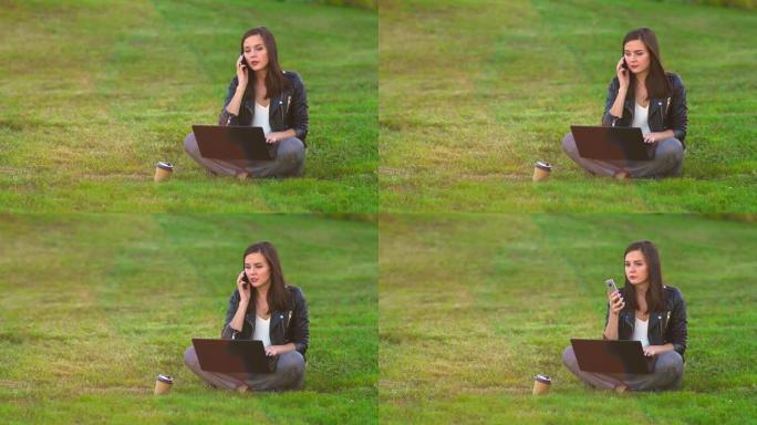 公园里草坪上的一个女孩在笔记本电脑上工作，电话铃响，接听来电。
