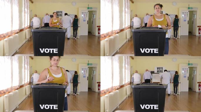 4K:妇女在选举投票站的投票箱内投票