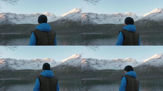 一个男人，一个中年运动员，在山里遇见夕阳。他欣赏太阳和湖中群山的倒影。